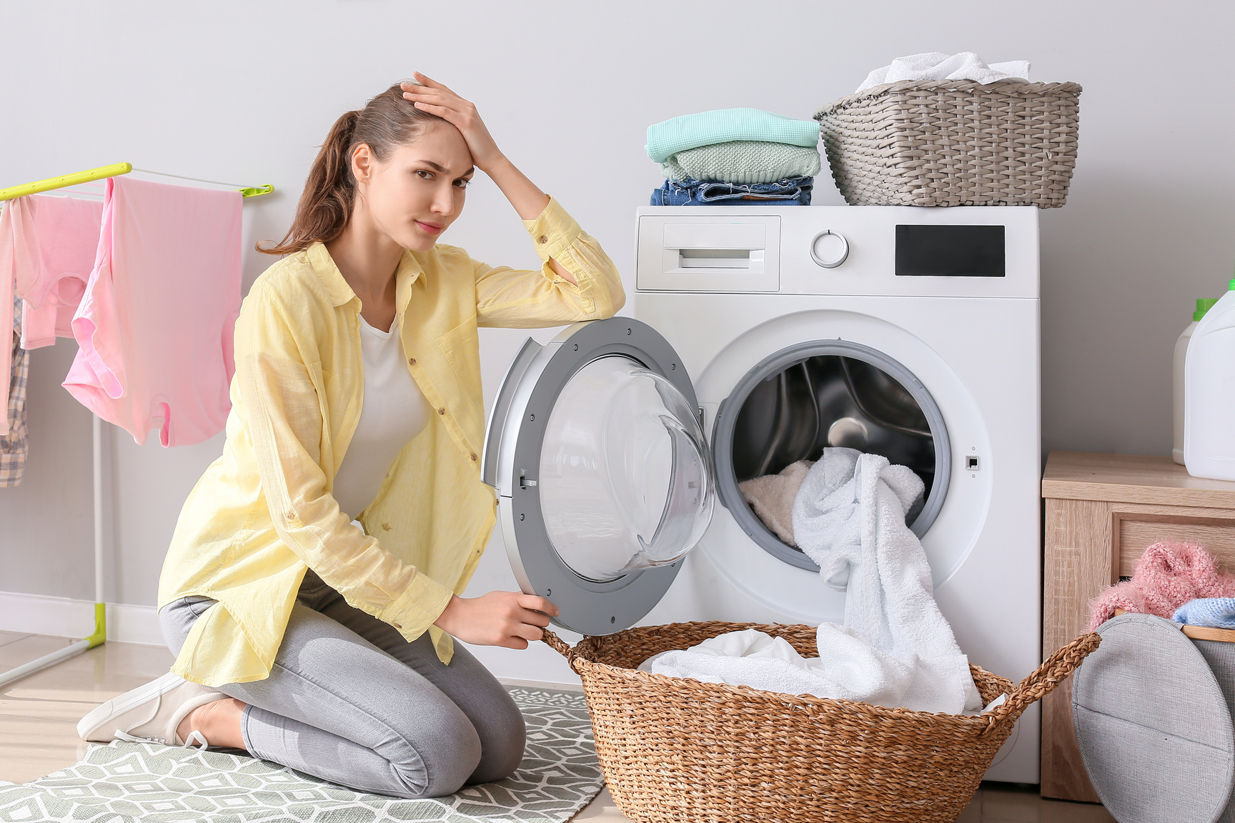 Tired Young Woman Doing Laundry in Laundry Room